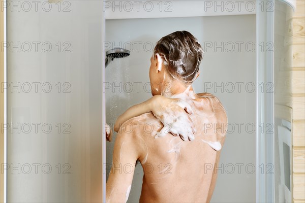 Back view of a man taking shower in cabin