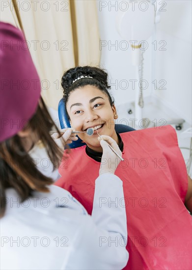 Patient lying on chair smiling at dentist