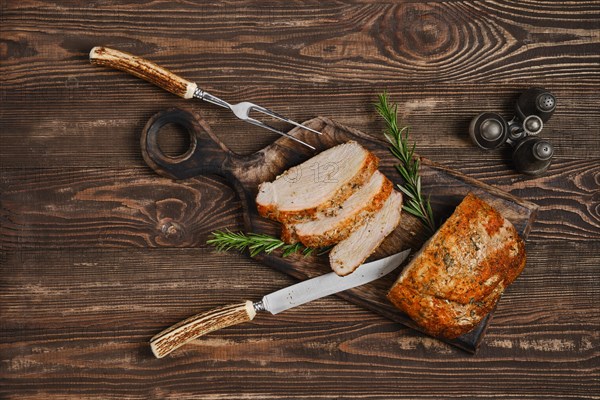 Top view of pork collar joint baked in oven on wooden cutting board