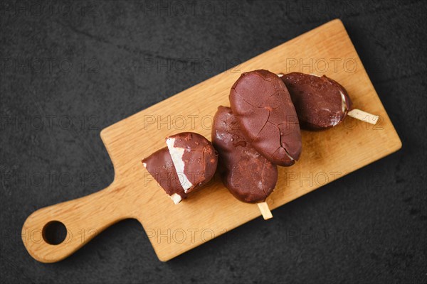 Top view of homemade curd bars in chocolate on wooden board