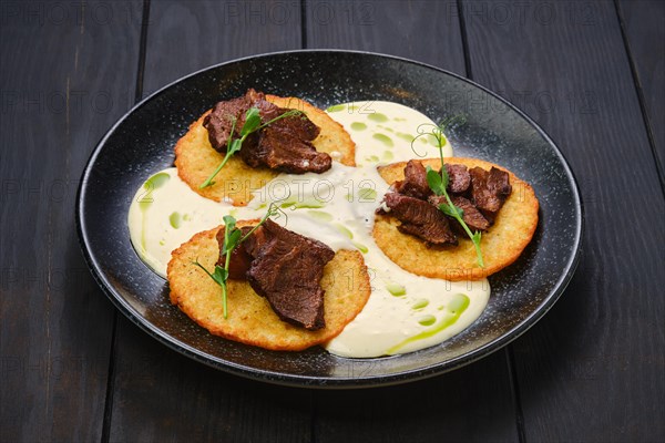 Potato fritters with with fried beef slices