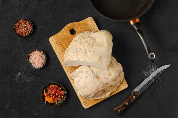 Overhead view of lamb fat tail on kitchen table with salt and pepper