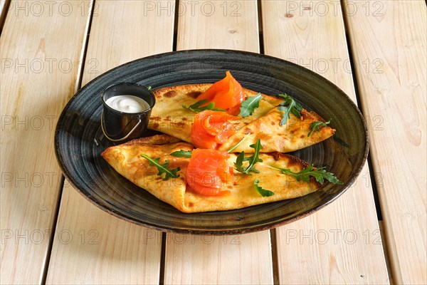 Thin pancakes with salmon and sour cream