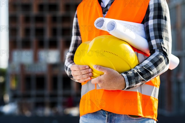 Close up construction engineer holding helmet