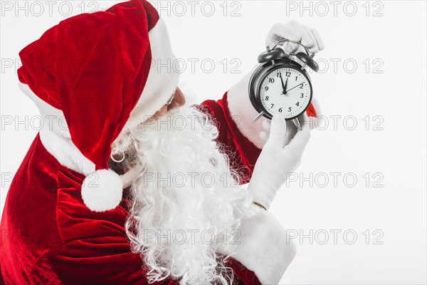 Santa claus looking at clock in hands