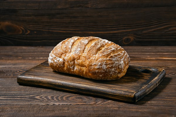 Artisan whole grain wheat bread on wooden board