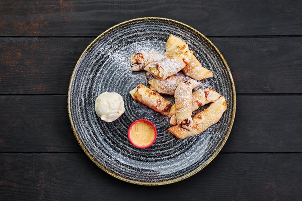 Top view of baked pear wrapped in pastry with cinnamon served with ice cream