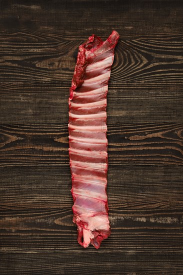 Overhead view of raw deer ribs over wooden background