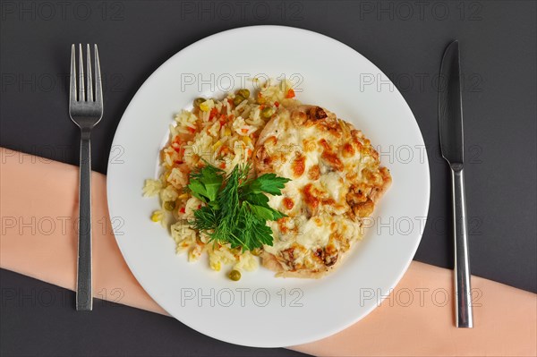 Top view of chicken fillet with mushrooms and cheese garnished with rice