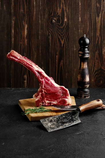 Raw prime ribeye steak on wooden cutting board