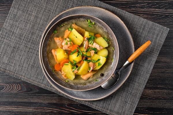 Top view of red salmon fish soup with potato and carrot