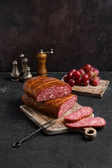 Homemade smoked beef sausage in organic casing on wooden cutting board