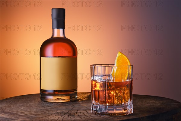 Bottle and glass with blended malt scotch whisky over blue and orange gradient background
