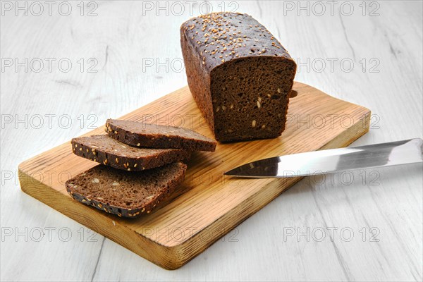 Top view of loaf of brown sourdough bread with sunflower seeds and sesame