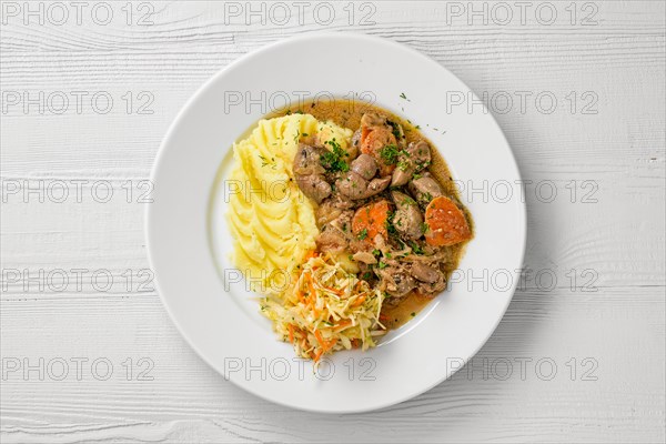 Top view of plate with chicken liver with mashed potato and pickled cabbage salad