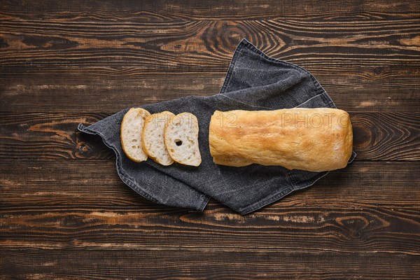 Freshly baked ciabatta on brown wooden table