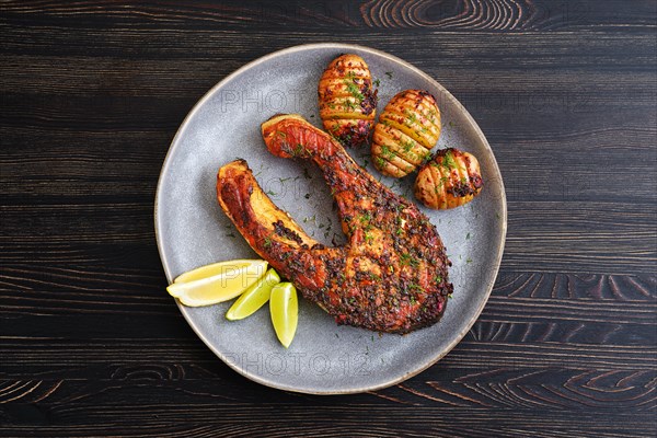 Plate with baked salmon steak with hasselback potatoes