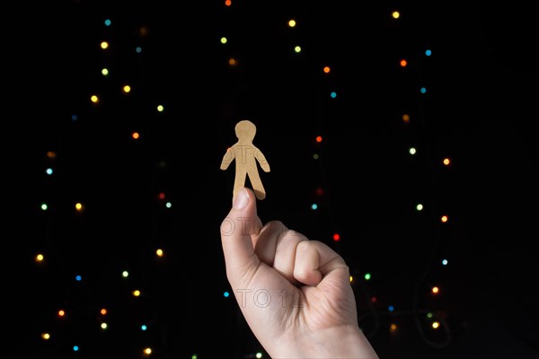 Paper man shape in hand on bokeh light background