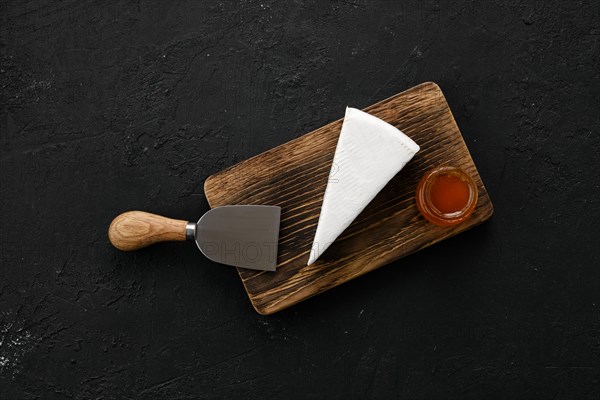 Piece of soft brie or camembert cheese on cutting board