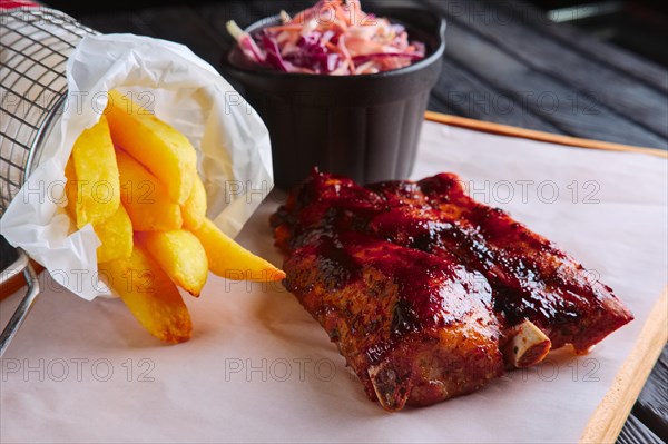 Rustic lunch. Grilled ribs with fried potato and red cabbage salad