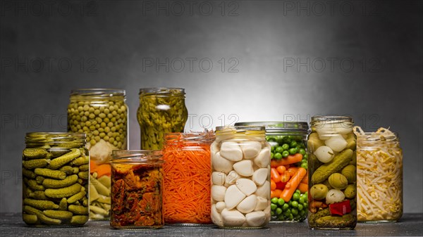 Front view assortment vegetables pickled glass jars