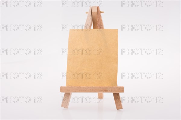 Brown color notepaper on a painting tripod on white background