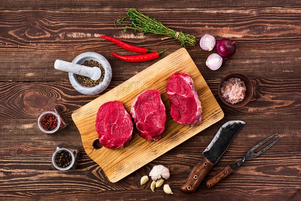 Overhead view of marinated beef fillet mignon with spice on wooden table