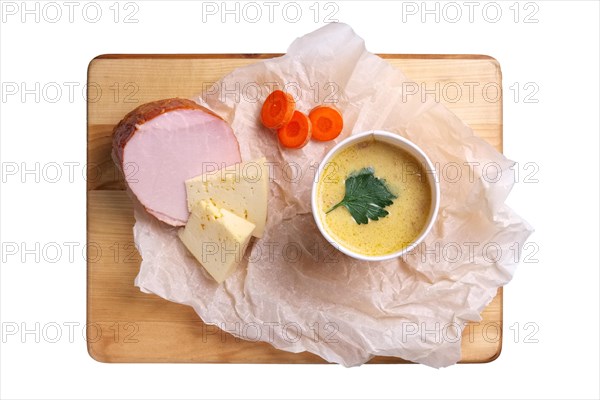 Top view of plate with cheese cream soup with ham isolated on white