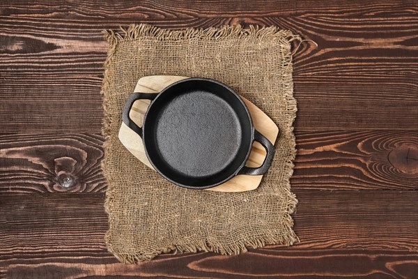 Empty mini cast-iron skillets on wooden table