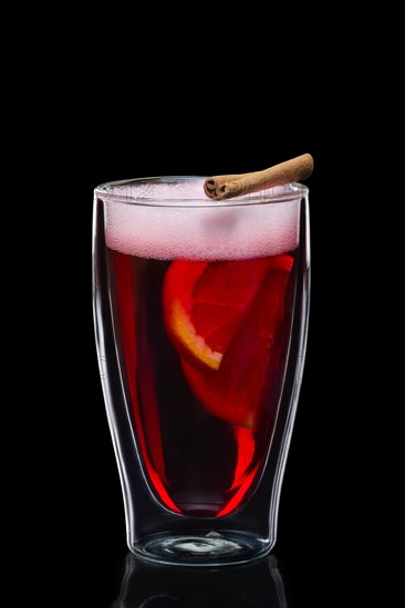 Double-walled glass with hot mulled wine isolated on black