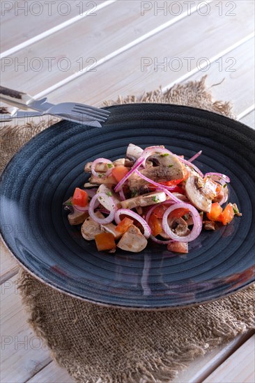 Lightly fried champignon with fresh onion rings and tomato. Snack for drink