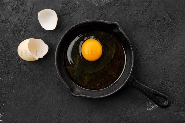 Raw uncooked egg in small cast iron skillet