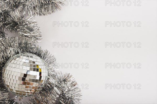 Disco ball with tinsel on white table