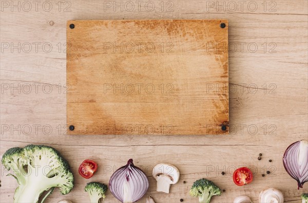 Wooden chopping board with broccoli tomatoes onion mushroom black pepper table. Resolution and high quality beautiful photo