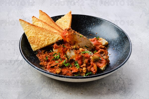 Fried zander served with steamed tomato