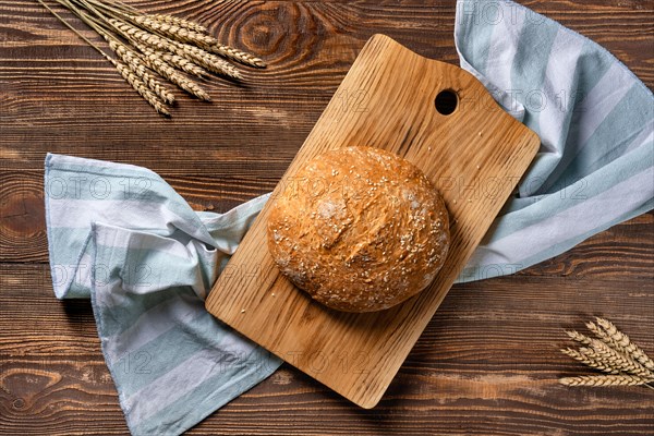 Overhead view of homemade wheat bread on wooden cutting board