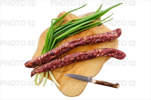 Top view of sun-dried pork sausage on wooden cutting board isolated on white background