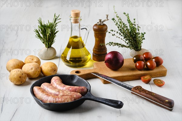 Homemade sausage stuffed with beef and turkey meat in frying pan