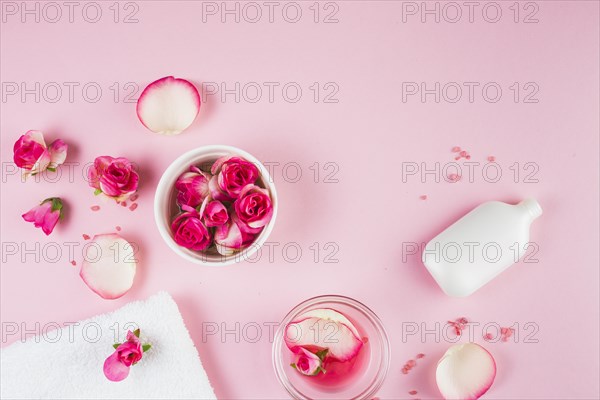 Elevated view towel flowers bottle pink background