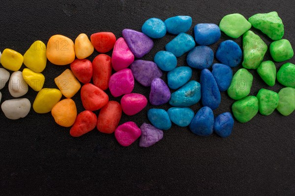 Pile of little colorful pebbles on black background