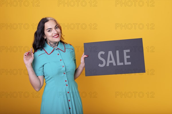 Beautiful woman holding a Sale sign. Commercial concept