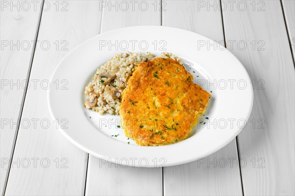 Schnitzel with green buckwheat on white wooden table