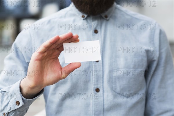 Close up businessman s hand showing white blank visiting card