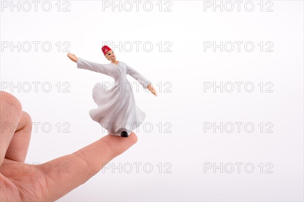 Hand holding a Sufi Dervis on a white background