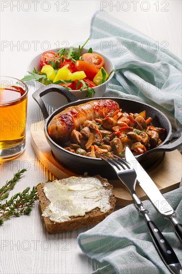 Fried mushrooms and egg in cast iron pan. Ingredients for rustic breakfast on wooden table