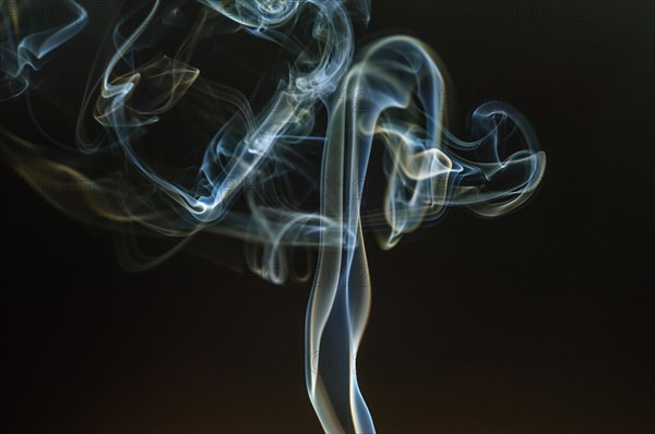 Trajectory of incense smoke in the air showing different shapes. France