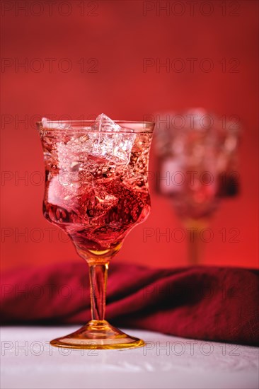 Soft focus photo of cocktail with gin and pomegranate bitter on red background