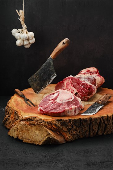 Chopping ossobuco steak from beef shank with cleaver on wooden stump