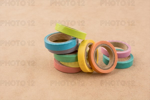 Colorful insulating adhesive tapes on yellow background