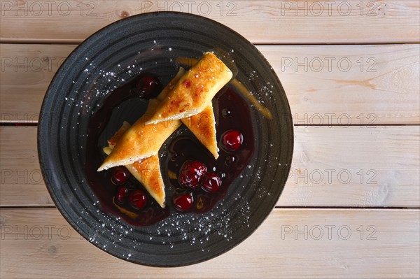Thin pancakes with curd and cherry jam
